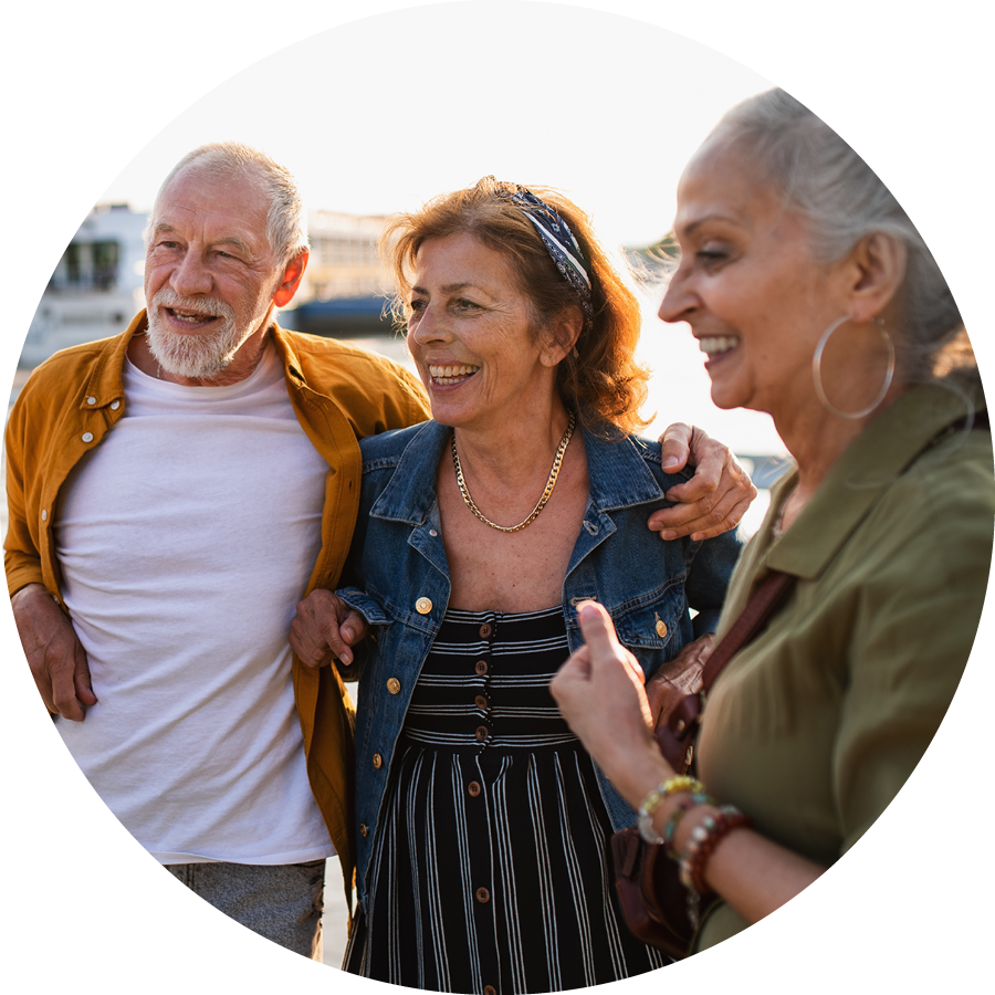 Tres adultos mayores sonriendo al sol
