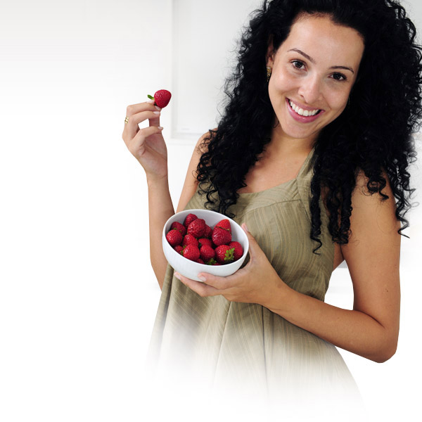 Una mujer que sostiene un tazón de fresas