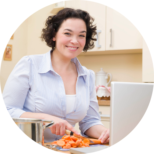 Una mujer que prepara una comida saludable frente a su computadora portátil